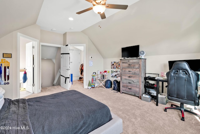 bedroom with ensuite bathroom, ceiling fan, light colored carpet, and vaulted ceiling