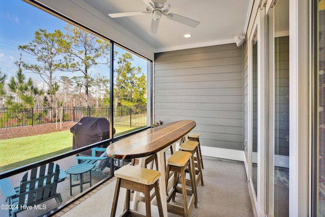 sunroom / solarium featuring ceiling fan