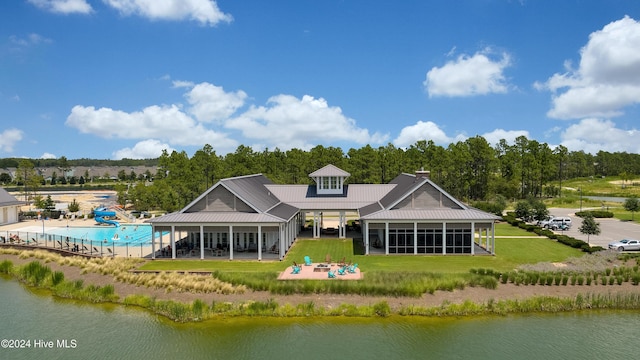 rear view of property featuring a sunroom and a water view