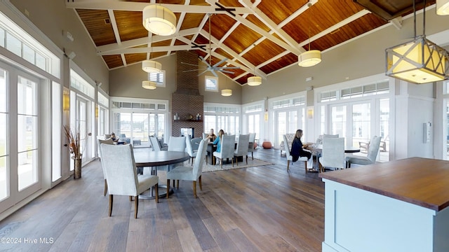 dining space featuring beamed ceiling, hardwood / wood-style floors, high vaulted ceiling, and wooden ceiling