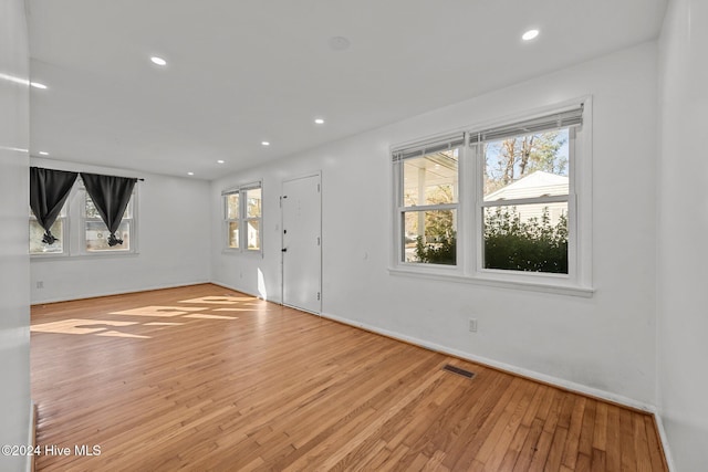 spare room with light wood-type flooring and a healthy amount of sunlight