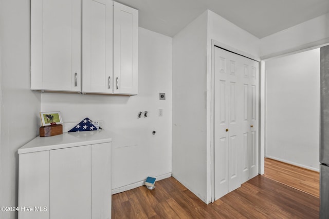 laundry room with cabinets, dark hardwood / wood-style flooring, and washer / clothes dryer