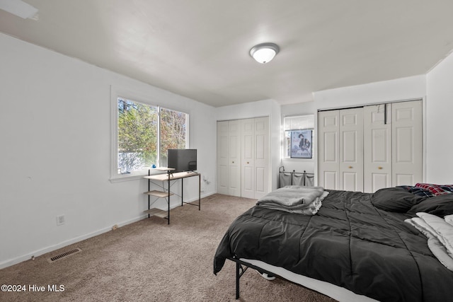 carpeted bedroom featuring two closets