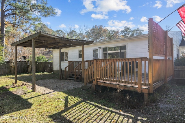 rear view of property featuring a yard and a wooden deck