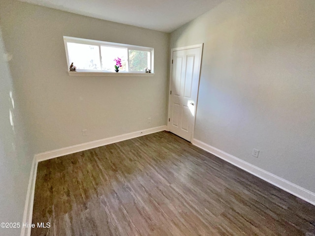 unfurnished room featuring dark wood-type flooring