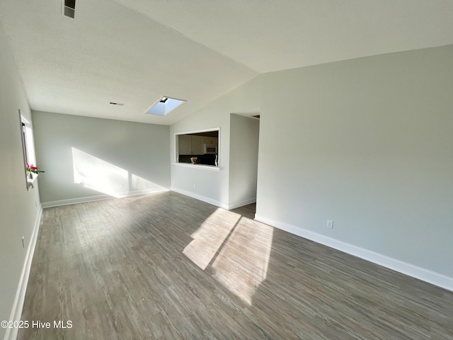 unfurnished room featuring dark hardwood / wood-style floors and vaulted ceiling with skylight