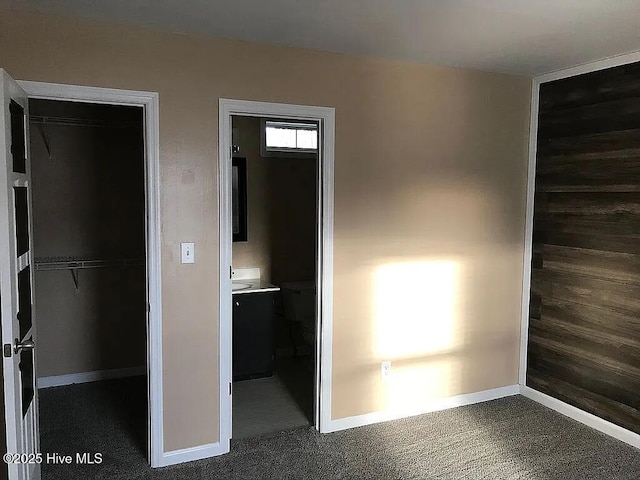 unfurnished bedroom featuring dark carpet and a closet