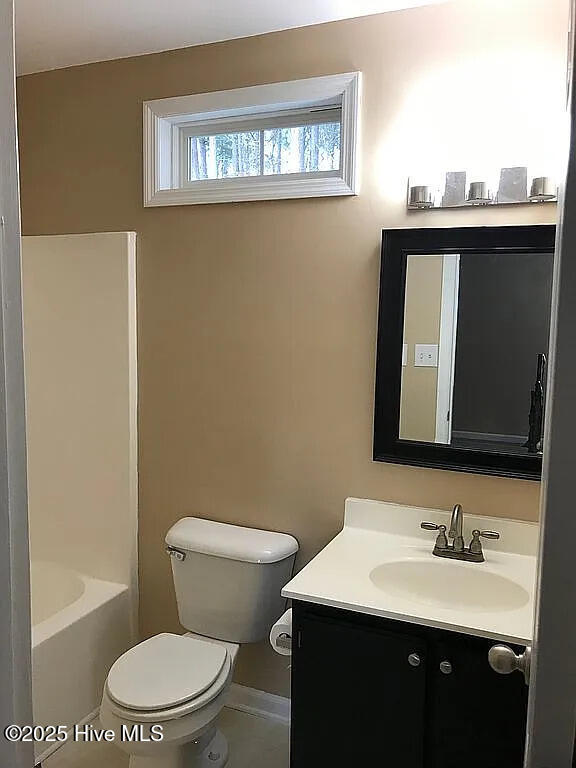 bathroom featuring tile patterned floors, vanity, and toilet