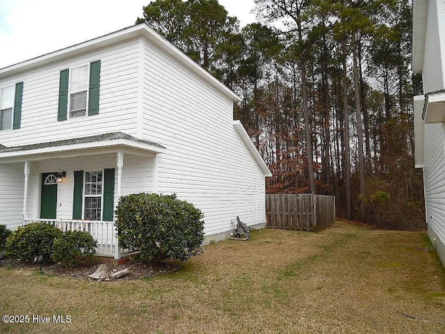 view of home's exterior featuring a porch and a yard