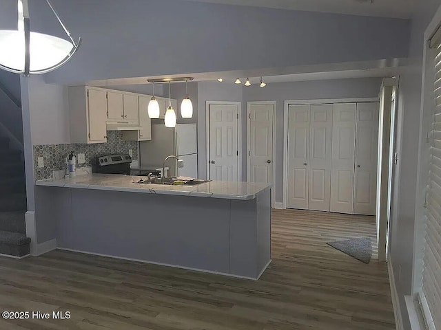 kitchen with white cabinetry, kitchen peninsula, backsplash, and stainless steel electric range oven