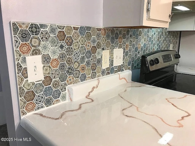 interior space featuring black range with electric stovetop and decorative backsplash