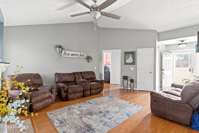 living room with ceiling fan, hardwood / wood-style floors, high vaulted ceiling, and a textured ceiling