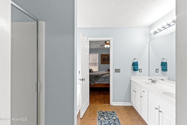 bathroom featuring tile patterned floors, vanity, ceiling fan, and a textured ceiling