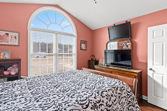 bedroom with a textured ceiling, hardwood / wood-style floors, and vaulted ceiling