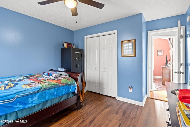 bedroom featuring a textured ceiling, a closet, dark wood-type flooring, and ceiling fan