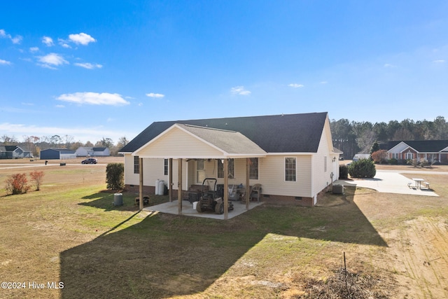 back of property with a yard and a patio area