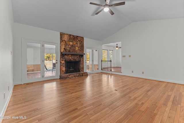 unfurnished living room with a fireplace, light wood-type flooring, ceiling fan, and lofted ceiling