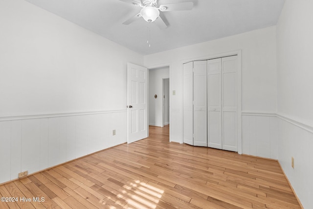 unfurnished bedroom featuring a closet, light hardwood / wood-style flooring, and ceiling fan