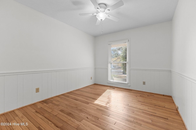 empty room with ceiling fan and light hardwood / wood-style flooring