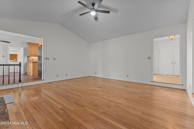 unfurnished living room featuring washer / dryer, light wood-type flooring, vaulted ceiling, and ceiling fan