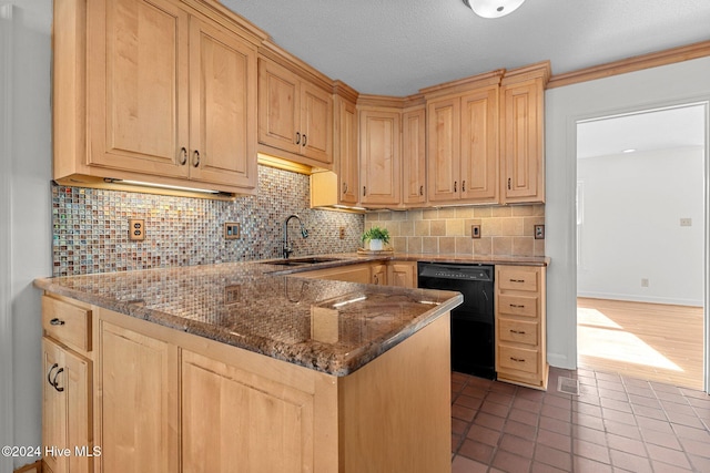 kitchen with sink, black dishwasher, tasteful backsplash, tile patterned floors, and dark stone countertops