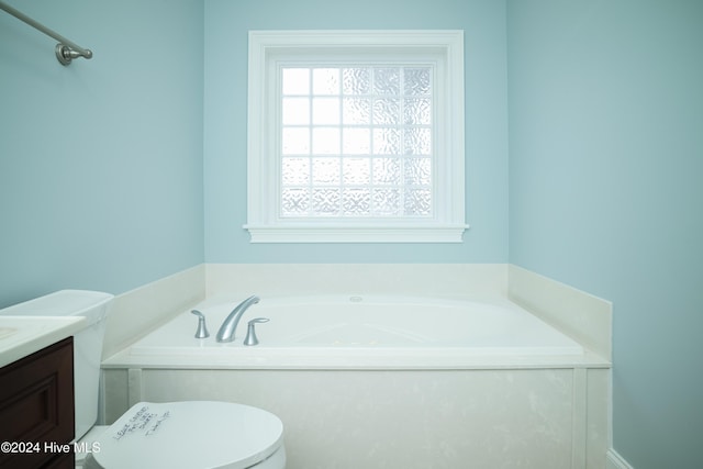 bathroom featuring a bathing tub, vanity, and toilet