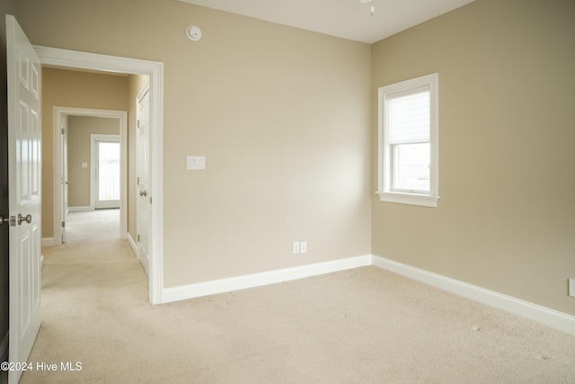 unfurnished room with a wealth of natural light and light colored carpet