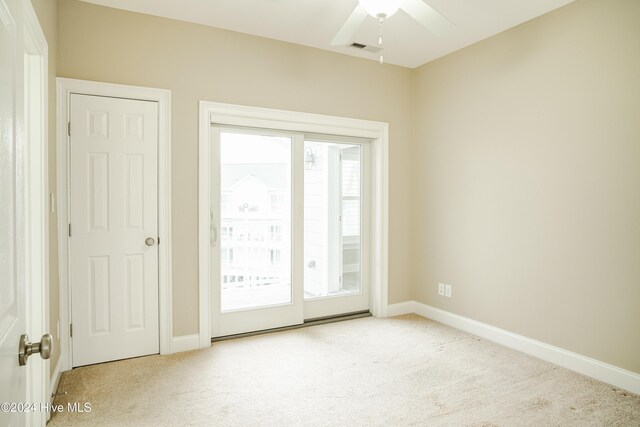 empty room with ceiling fan, plenty of natural light, and light colored carpet