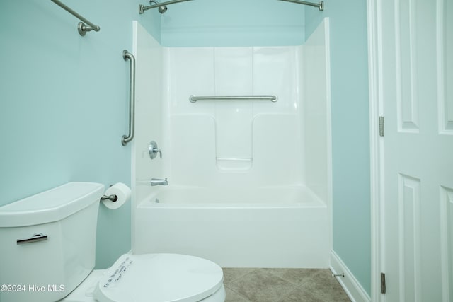 bathroom with tile patterned flooring, washtub / shower combination, and toilet