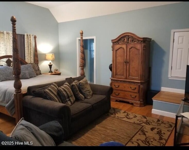 bedroom with lofted ceiling and light wood-type flooring