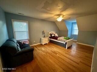 bedroom featuring vaulted ceiling, baseboards, a ceiling fan, and wood finished floors