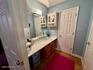 bathroom with baseboards, vanity, and wood finished floors