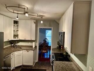 kitchen featuring stainless steel microwave, a sink, range, white cabinetry, and glass insert cabinets