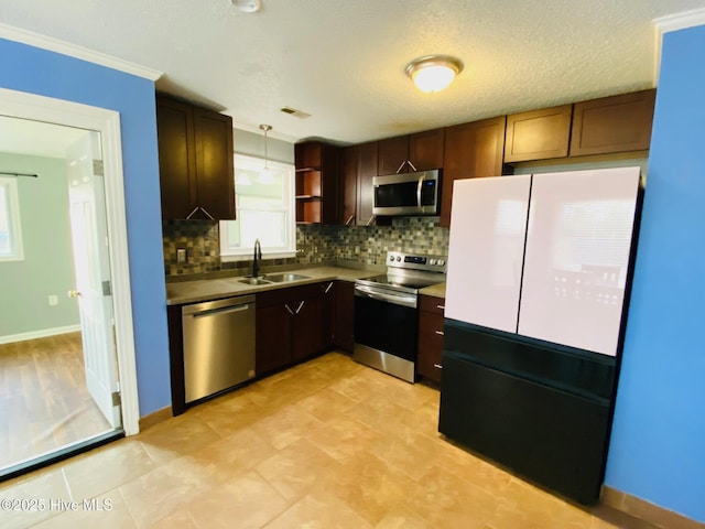 kitchen with decorative backsplash, sink, pendant lighting, and appliances with stainless steel finishes