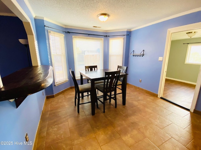 dining room with a textured ceiling and crown molding