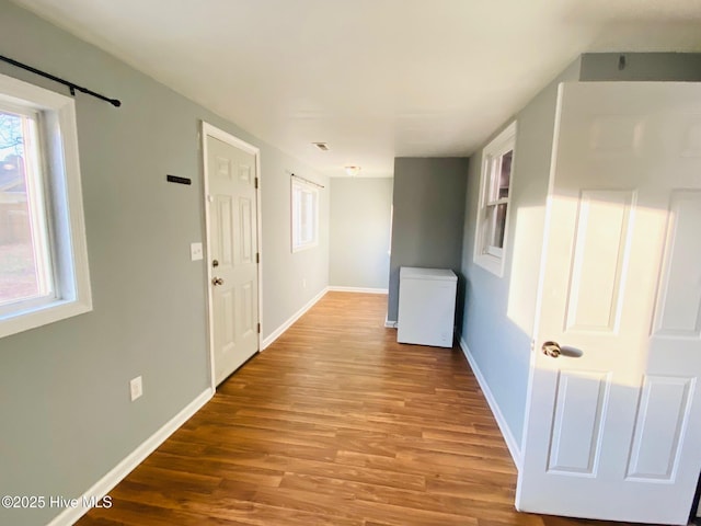 corridor with hardwood / wood-style floors