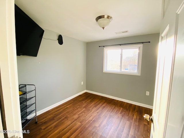 empty room with dark hardwood / wood-style flooring