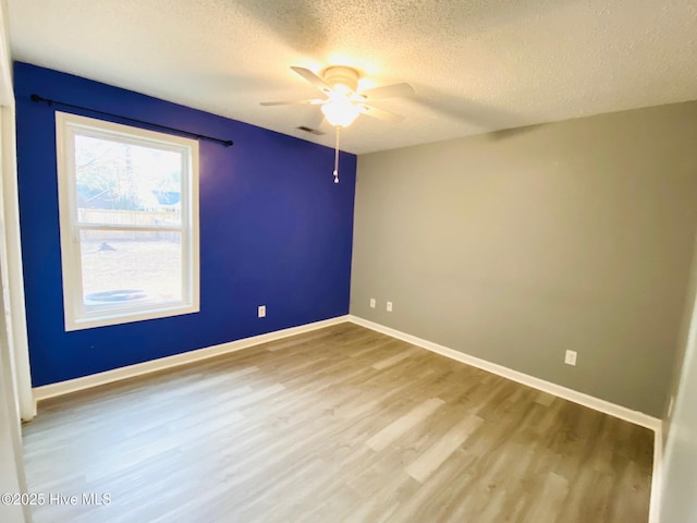 unfurnished room with a textured ceiling, ceiling fan, and hardwood / wood-style flooring