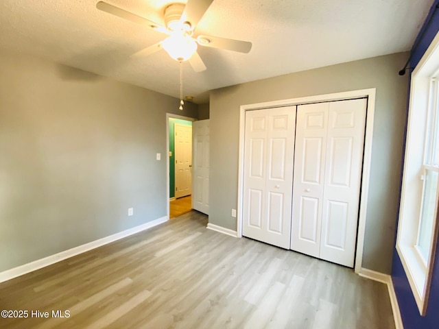 unfurnished bedroom with ceiling fan, light hardwood / wood-style floors, and a closet