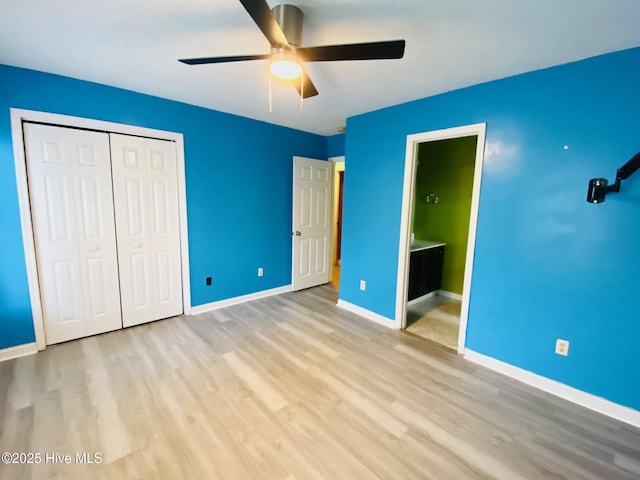 unfurnished bedroom with ceiling fan, a closet, light hardwood / wood-style floors, and ensuite bath