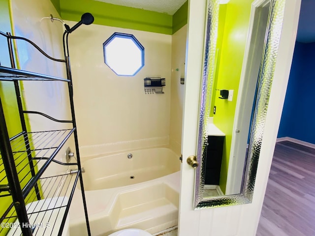 bathroom with hardwood / wood-style flooring, bathtub / shower combination, and a textured ceiling