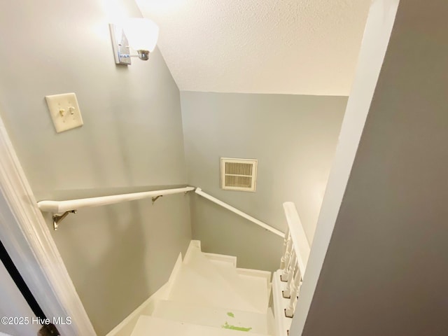 stairs with a textured ceiling