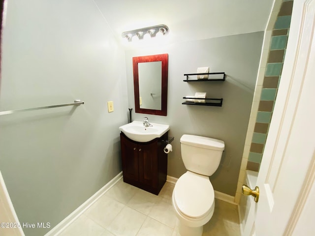 bathroom with toilet, vanity, and tile patterned flooring