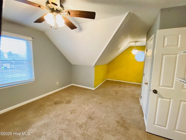 bonus room featuring ceiling fan, vaulted ceiling, and light carpet