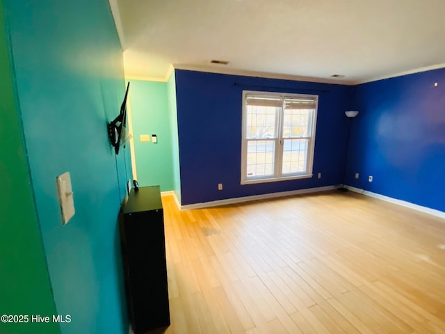 unfurnished room featuring light wood-type flooring and ornamental molding