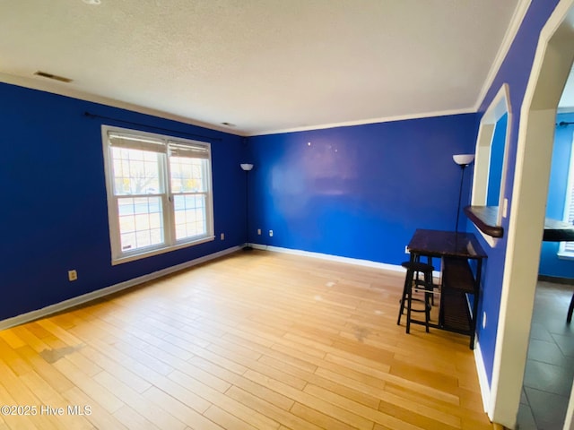 unfurnished living room with wood-type flooring and ornamental molding