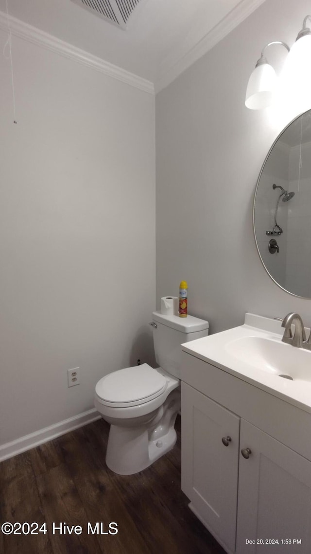 bathroom featuring vanity, toilet, wood-type flooring, and ornamental molding