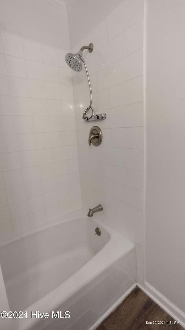 bathroom with tiled shower / bath combo and wood-type flooring