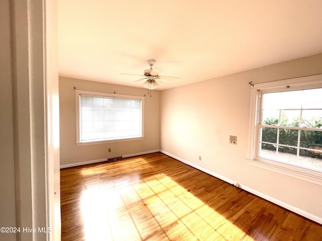 empty room with ceiling fan and light hardwood / wood-style flooring