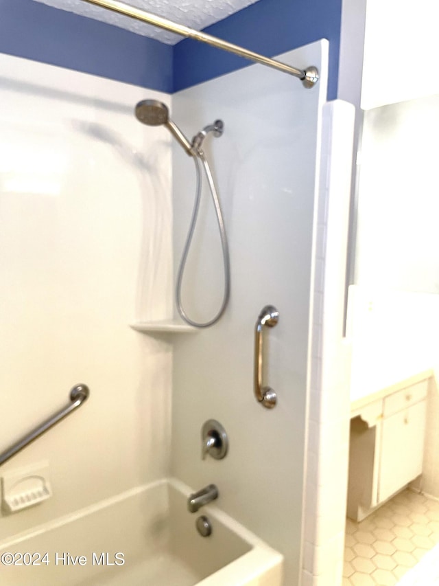 bathroom with tile patterned floors and shower / washtub combination